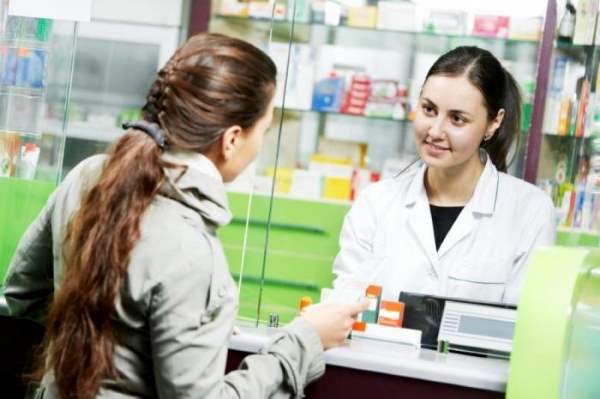 девушка покупает лекарства в аптеке