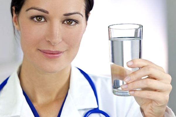 врач держит стакан с водой