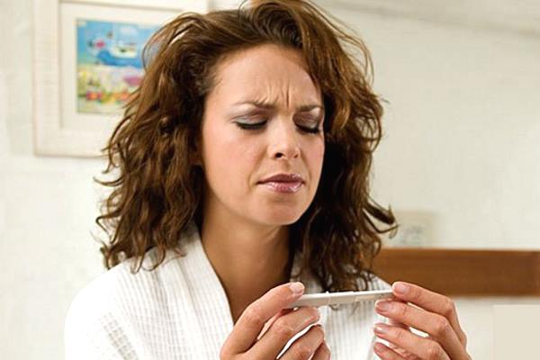 девушка определяет беременность прибором