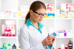 фармацевт читает название препарата