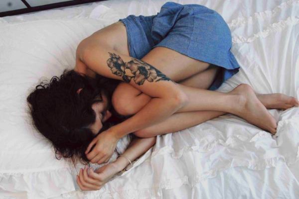 на кровати лежит скрюченная девушка