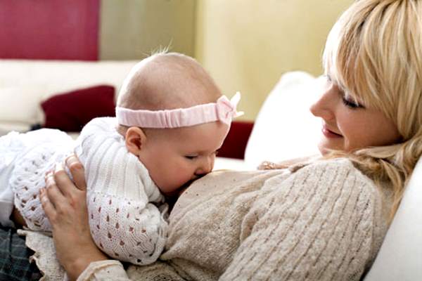 женщина кормит грудью малыша