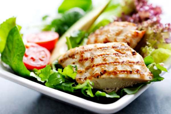 кусок мяса гриль на листьях салата