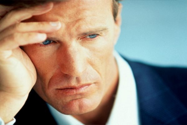 мужчина держится за голову