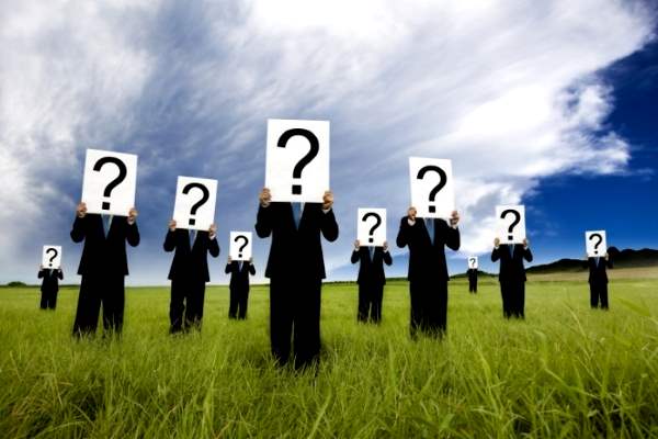 люди в костюмах со знаками вопроса